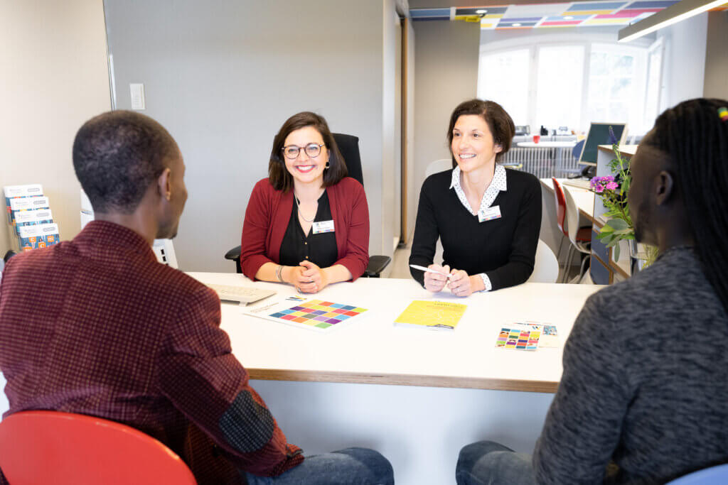 Beratung im Welcome Center Stuttgart mit vier Personen um den Schreibtisch